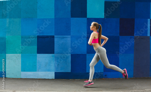 Young woman running in city copy space