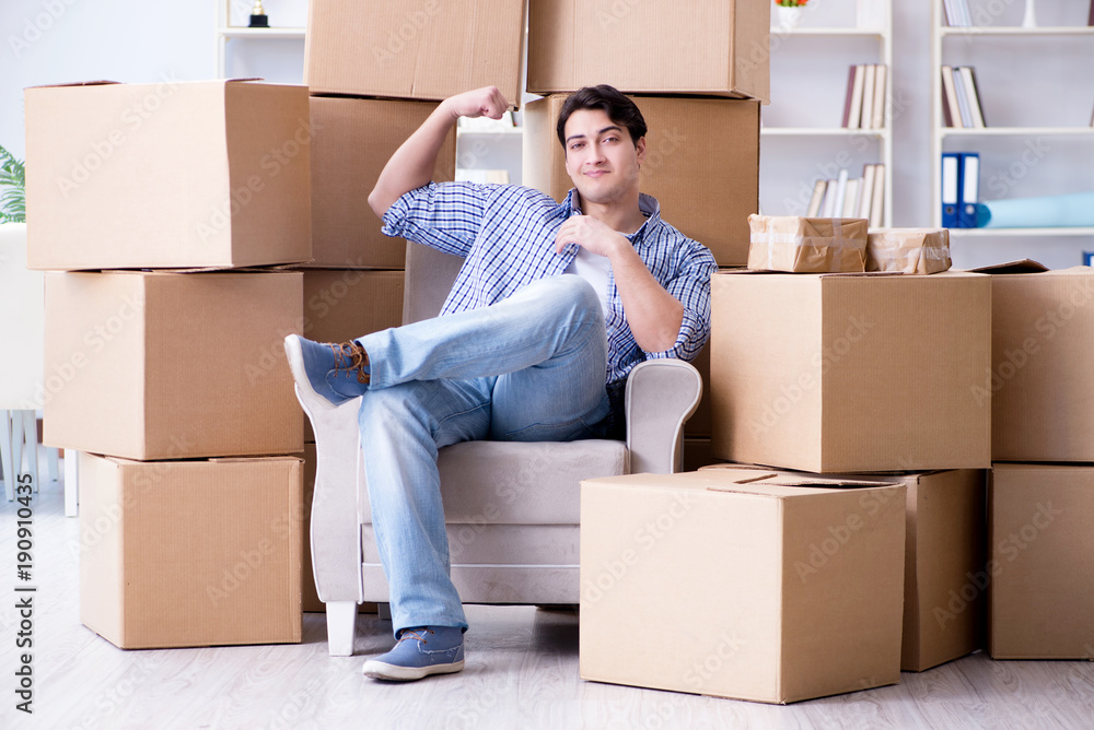 Young man moving in to new house with boxes Young man moving in to new house with boxes