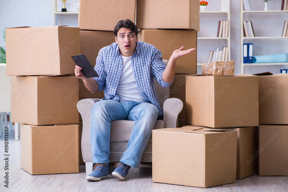 Young man moving in to new house with boxes Young man moving in to new house with boxes
