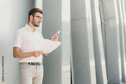 Young businessman working with papers outdoors