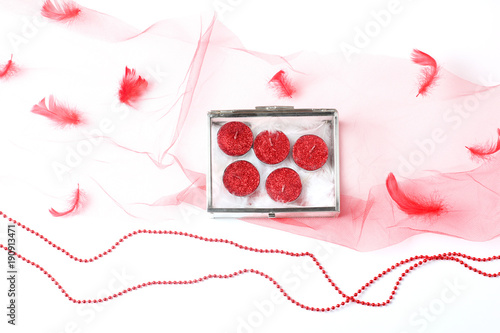 beautiful composition of a red veil and a glass box with candles in glitter. flat lay, top view, creative layout photo