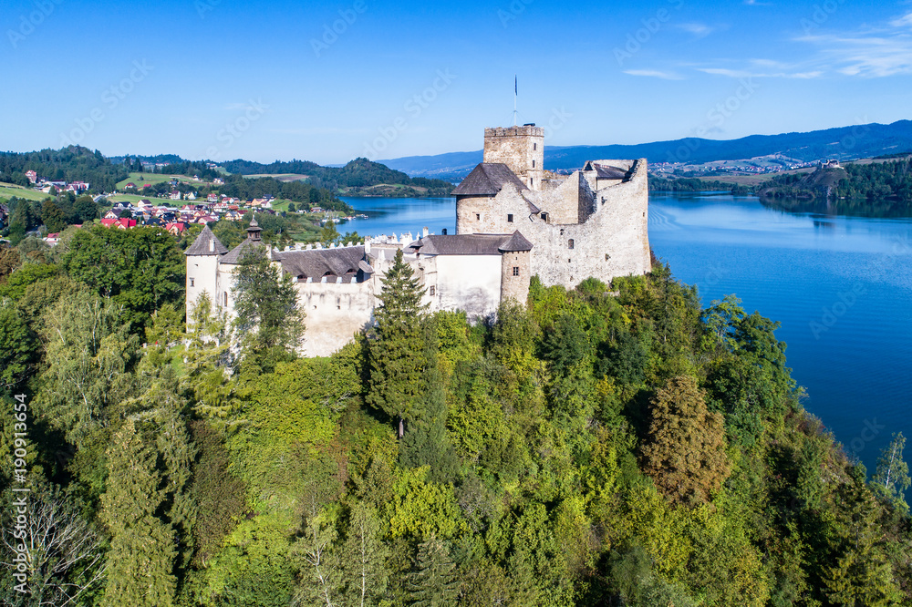 Poland. Medieval Castle in Niedzica, built in 14th century, artificial Czorsztyn Lake and far view of the ruins of Czorsztyn castle, Aerial view in the morning
