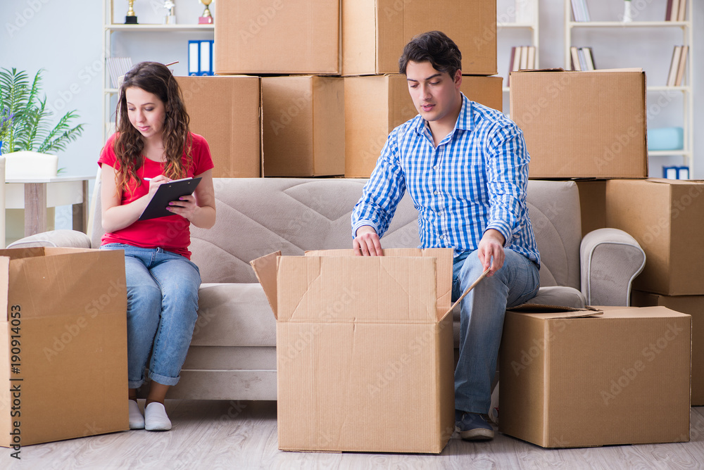 Young pair moving in to new house with boxes Young pair moving in to new house with boxes