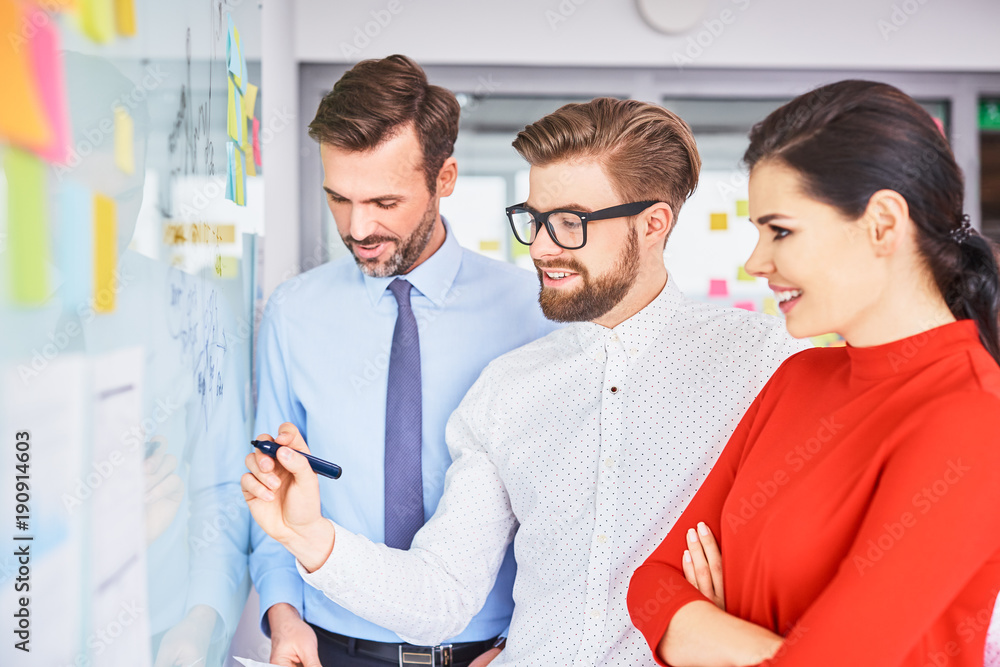 Three creative businesspeople brainstorming and coworking in office together Three creative businesspeople brainstorming and coworking in office together