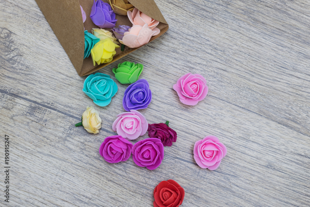 Group of colored flowers sticking out of the craft envelope.
