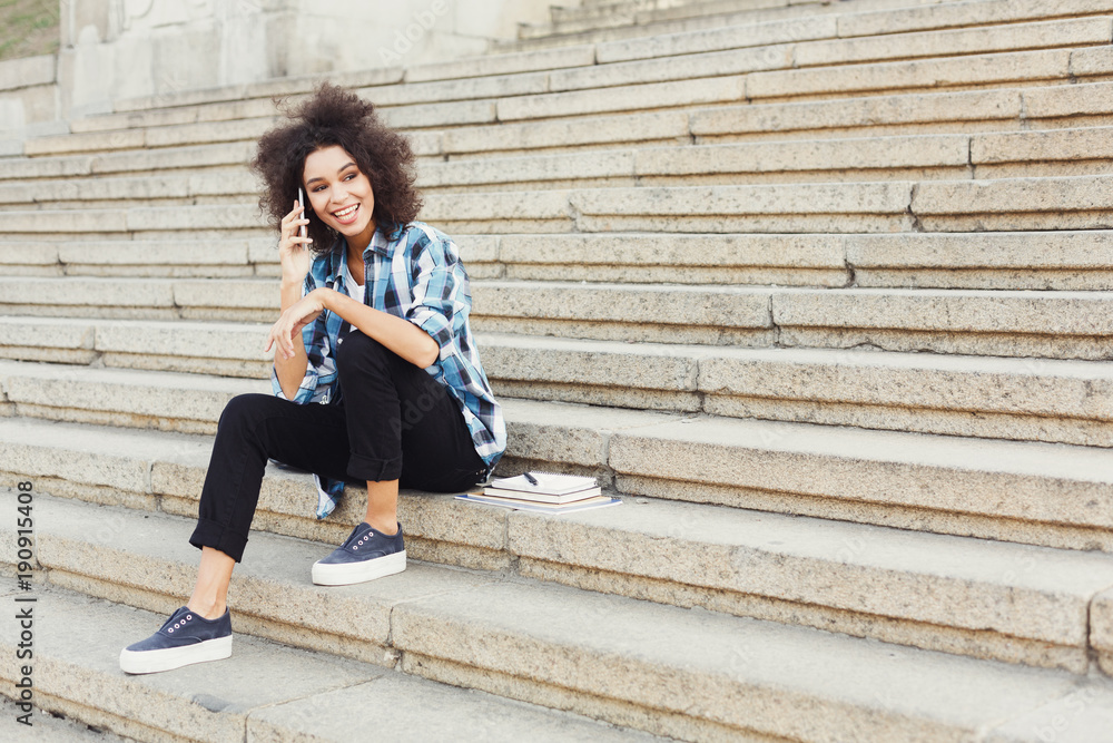 Obraz premium Young smiling woman talking on phone outdoors