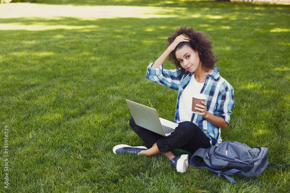 Pensive young woman using laptop in park Pensive young woman using laptop in park