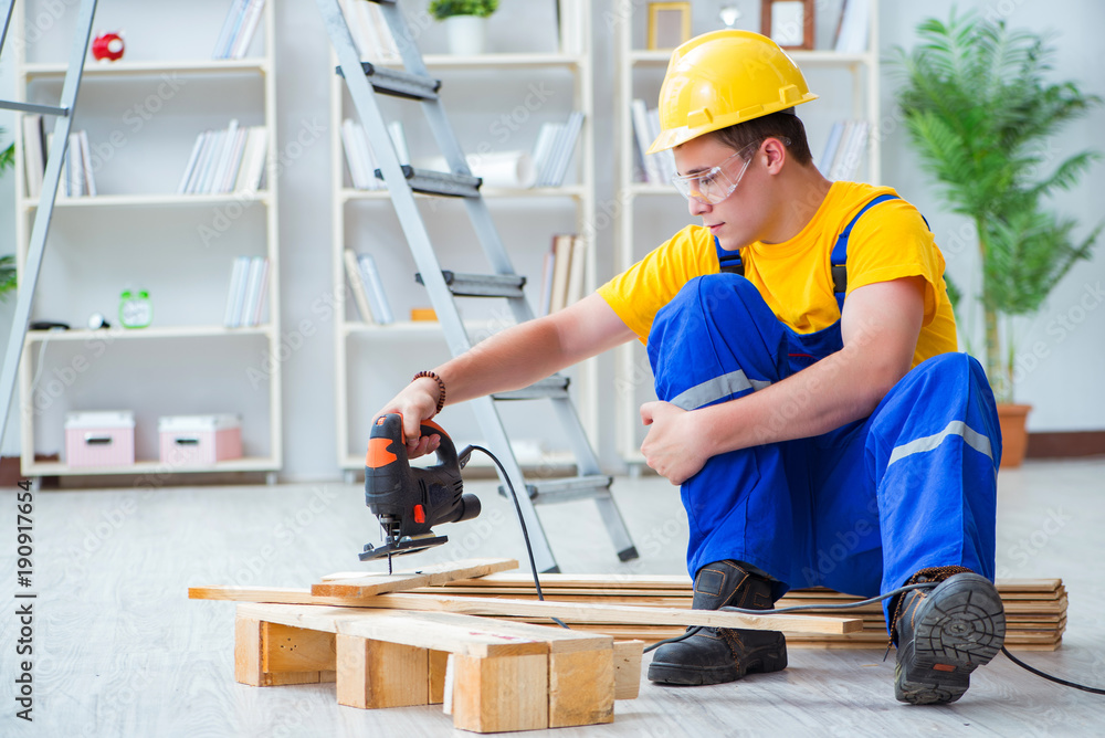 Young man assembling wood pallet Young man assembling wood pallet
