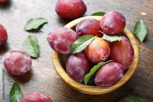 plums in a wooden plate
