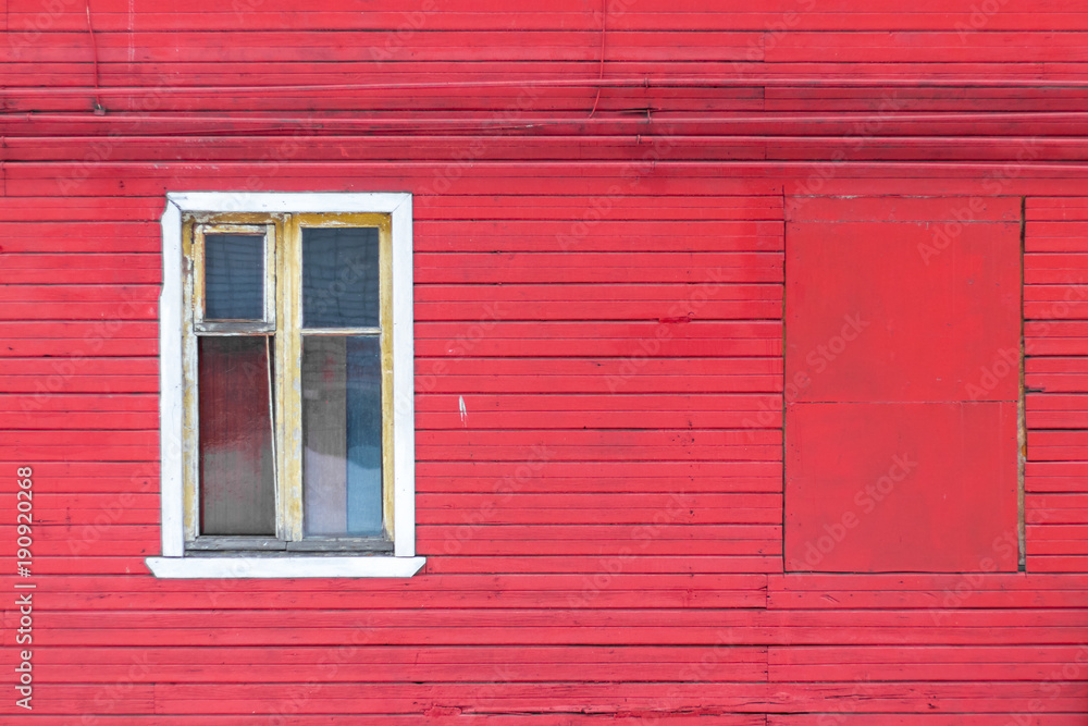 White wooden window on a red wooden house wall White wooden window on a red wooden house wall