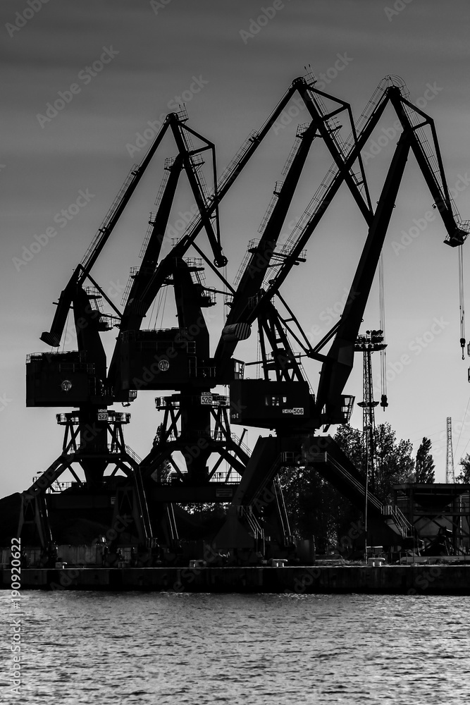 Obraz premium Gdansk shipyard, Poland. Retro style black and white. Cranes, old shipyard buildings, rusty structures.
