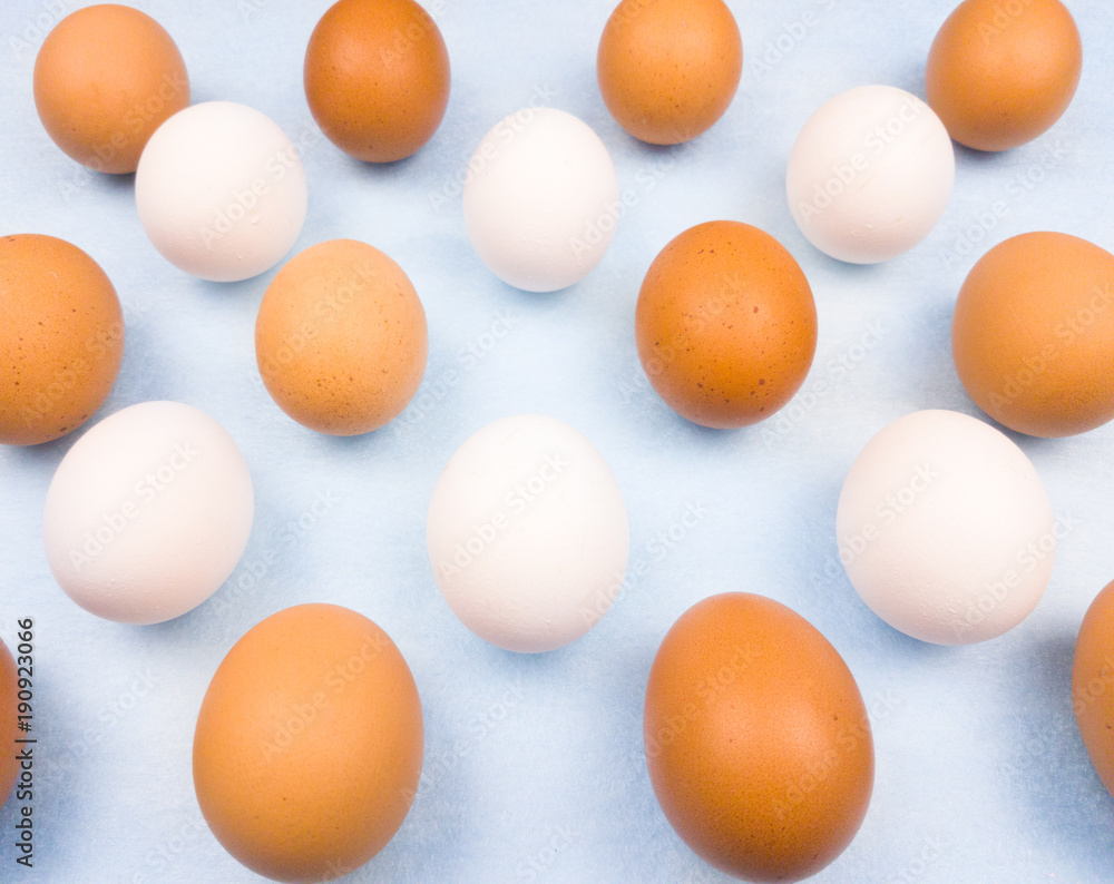 White and yellow easter eggs on pastel blue background close up macro. White and yellow easter eggs on pastel blue background close up macro.