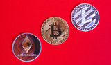 Gold bitcoins digital virtual money on a red background. Metal gold money bitmoy Credit coins - bitkoyn BTK , lithecoin LTC , etherum ETH digital cryptococci