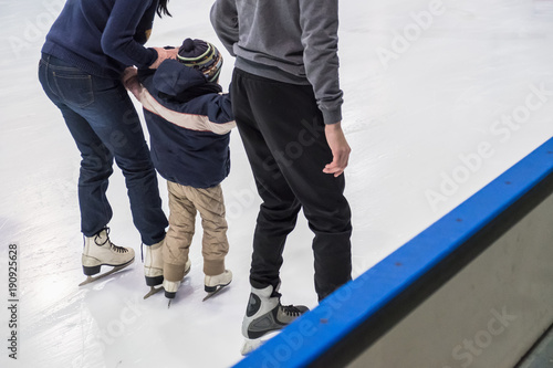 Canvas Print Happy family indoor ice skating at rink. Winter