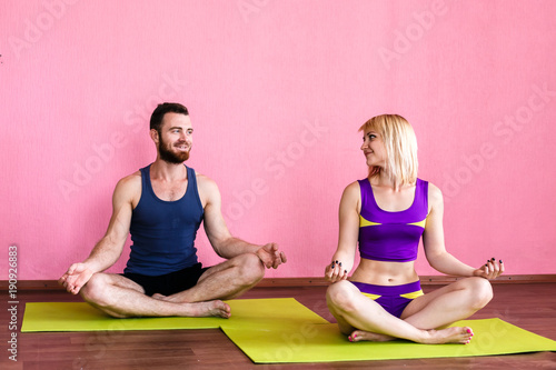 Young couple meditating in lotus position.