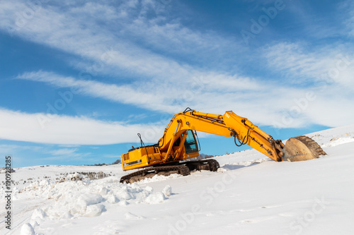 Heavy Duty construction equipment parked at work site and winter.