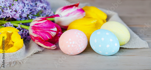 Easter eggs and spring flowers, Easter decoration on a wooden background, holiday concept.