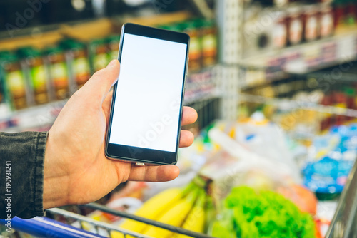 man look into phone for a shopping list