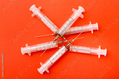 Used syringes on a red background. Heroin Epidemic. The preparation of therapeutic drugs, occured injecting , heroin, drugs. Opioid epidemic.