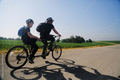 Fotografía father and son ride a tandem bike