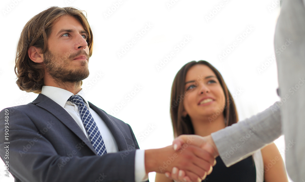Businesspeople shaking hands against room with large window loo Businesspeople shaking hands against room with large window loo