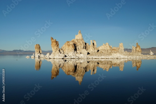 Mono Lake salt rock formation mirror reflection in deep blue water and sky