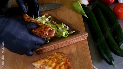 Man prepares lunch, serves grilled bread sandwich snack on top of wooden cutting board, with side of green salad, healthy alternative to burgers and grease slow moyion photo