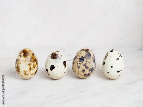 Four quail eggs on a marble background