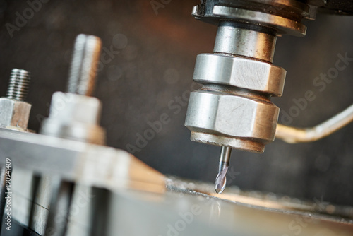 drill drilling a hole on metalworking machine photo