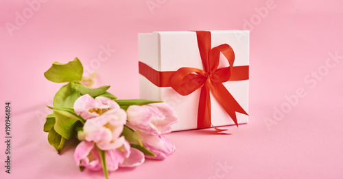 Valentines day background with pink tulips and gift box over pink background. Space for text © Agave Studio