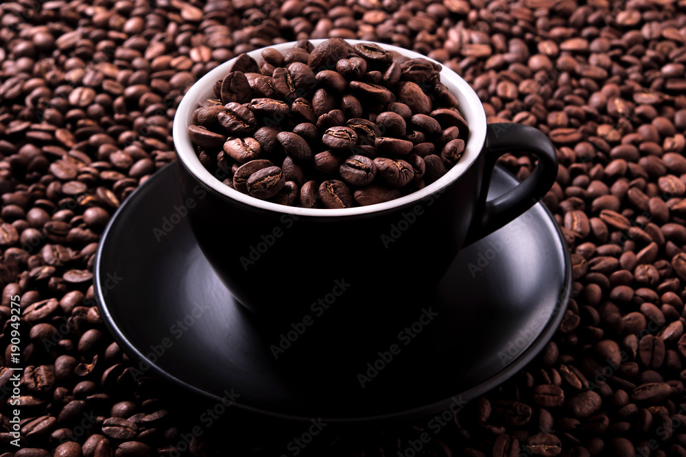 Fototapeta premium Black coffee cup and saucer one single for espresso or capuccino on a background of scattered dark coffee beans photo 