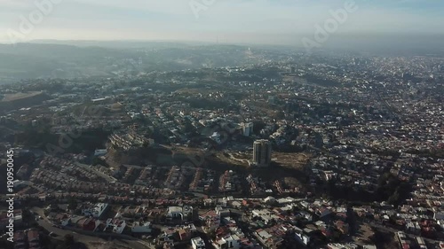 erial footage of a residential area in Tijuana, Baja California, Mexico during a Santana, local name for sand storm. High density of houses in a desert area, dusty sky. photo