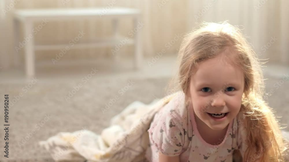 Happy woman and girls playing in ghost lying on the floor at home Happy woman and girls playing in ghost lying on the floor at home