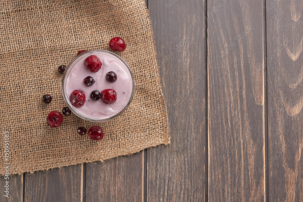 yogurt in a glass with berries on sacking and texture yogurt in a glass with berries on sacking and texture