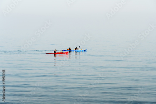 Organized group of people in kayaks floating in the sea