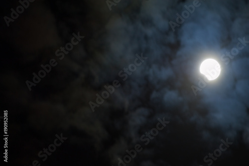 Partial solar eclipse through clouds and a dark sky