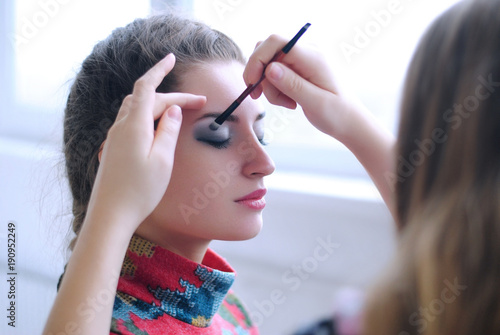 Визажист делает макияж модели бекстейдж photo