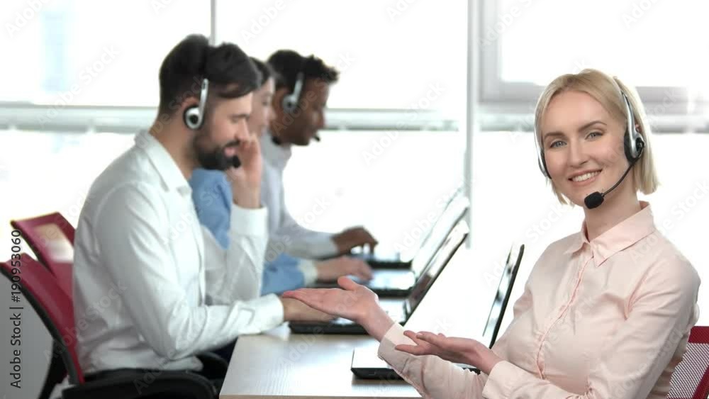 Cheerful lady presenting her co-workers. Blond woman presenting her colleagues pointing at them with both palms. Cheerful lady presenting her co-workers. Blond woman presenting her colleagues pointing at them with both palms.