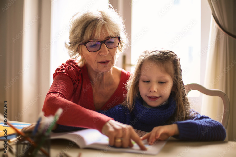 Grandmother teaching to her granddaughter Grandmother teaching to her granddaughter
