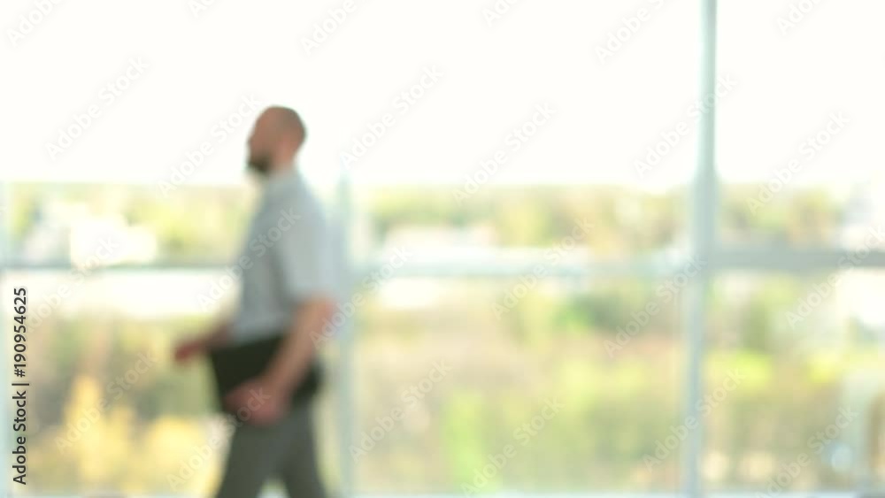 Office colleagues handshake. Concept of man following woman in office, blur, side view. Office colleagues handshake. Concept of man following woman in office, blur, side view.