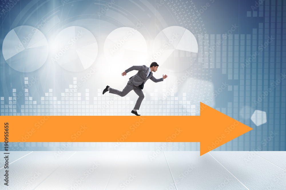 Businessman walking on arrow in business concept Businessman walking on arrow in business concept