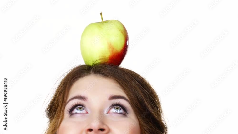 Woman young female holding big red green apple fruit on top of head looking up. Healthy eating, vegetarian food, dieting concept Woman young female holding big red green apple fruit on top of head looking up. Healthy eating, vegetarian food, dieting concept