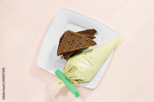 Two slices of rye bread on a plate with avocado on a light background photo