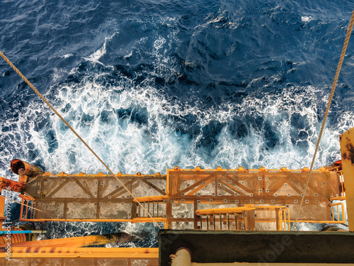 Offshore oil and gas platform at boat landing while the high wave in the sea hit the boat landing.