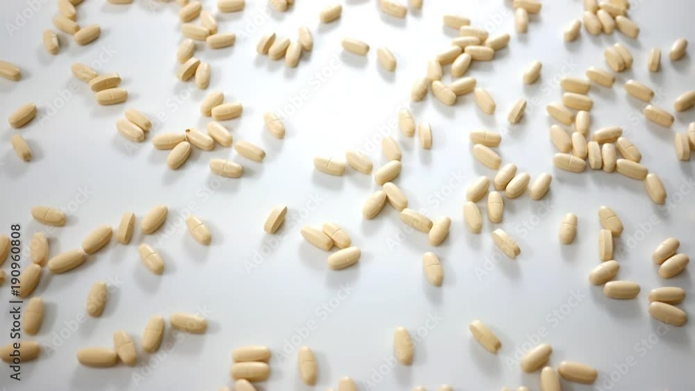 Spinning Vitamin B pills over white studio background - Above Angle Spinning Vitamin B pills over white studio background - Above Angle