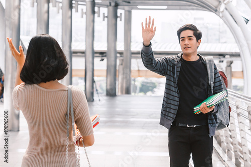 Fotografija Happy students waving and saying hello with friend