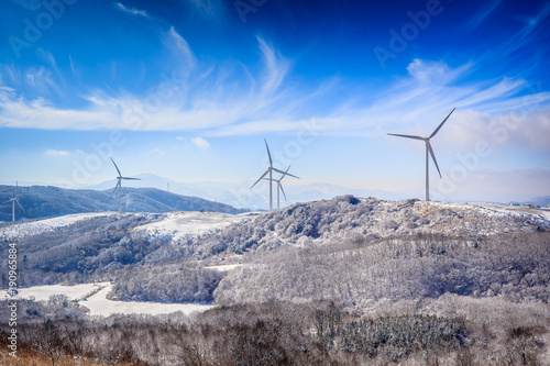 A beautiful scene with white snow. blue sky and windmill