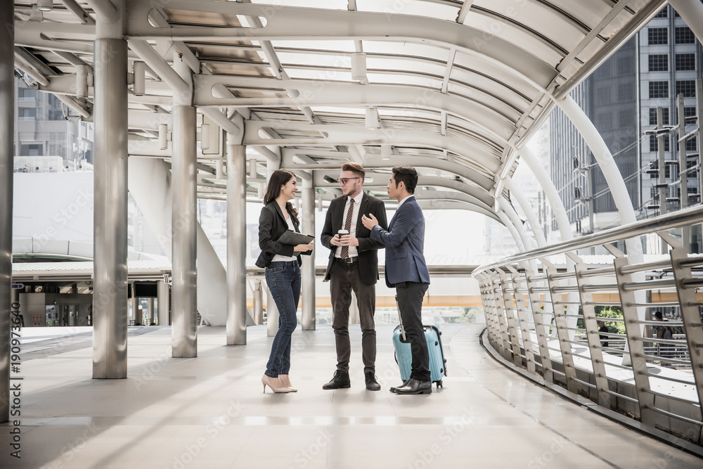 Team of business colleagues meeting while walking in a modern city to go travelling. Business travel concept.