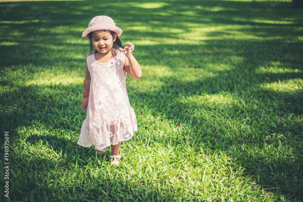 Little girl walking alone in a park or forest Little girl walking alone in a park or forest