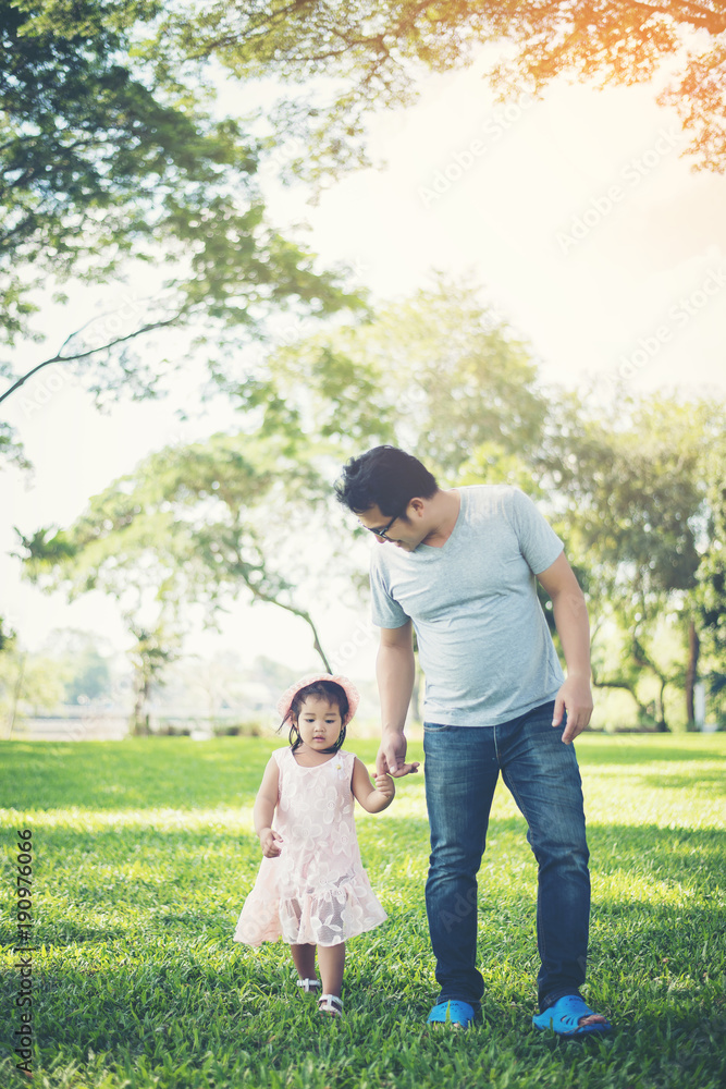 Toddler girl holding hands with her father in the park, happiness time. Toddler girl holding hands with her father in the park, happiness time.
